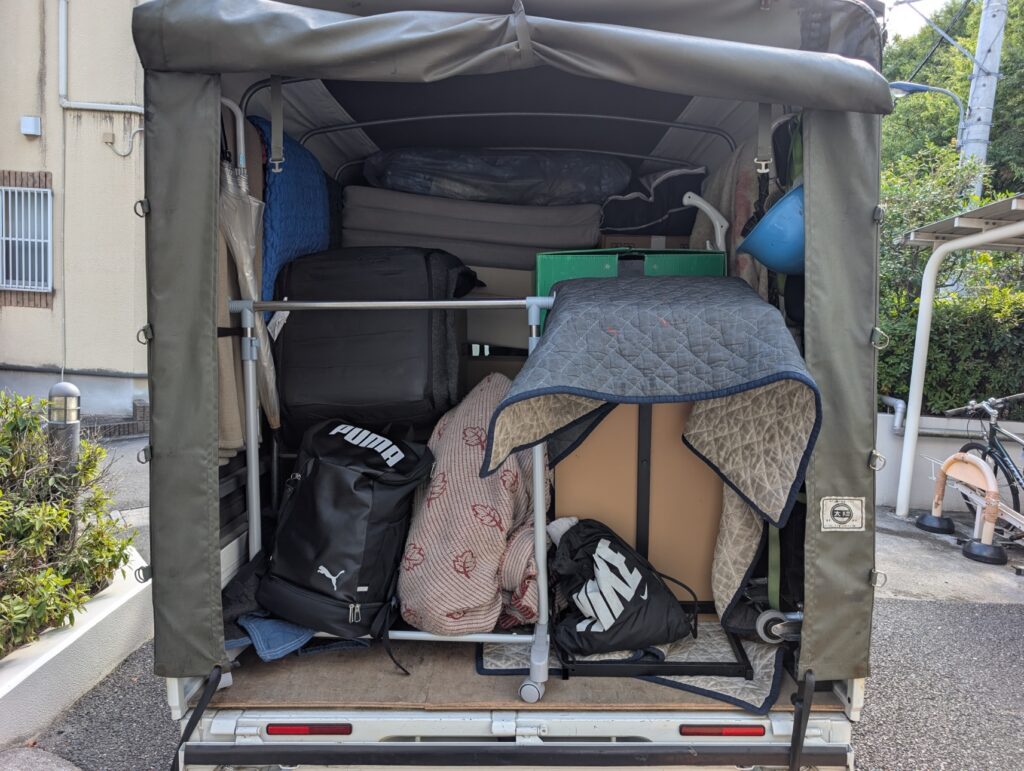 布団や段ボールなど単身引越しの荷物を満載した赤帽車両の荷台