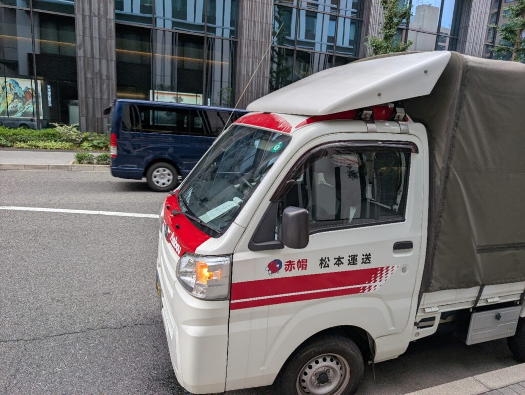 名古屋市中区の建設会社前に駐車する赤帽松本運送のトラック