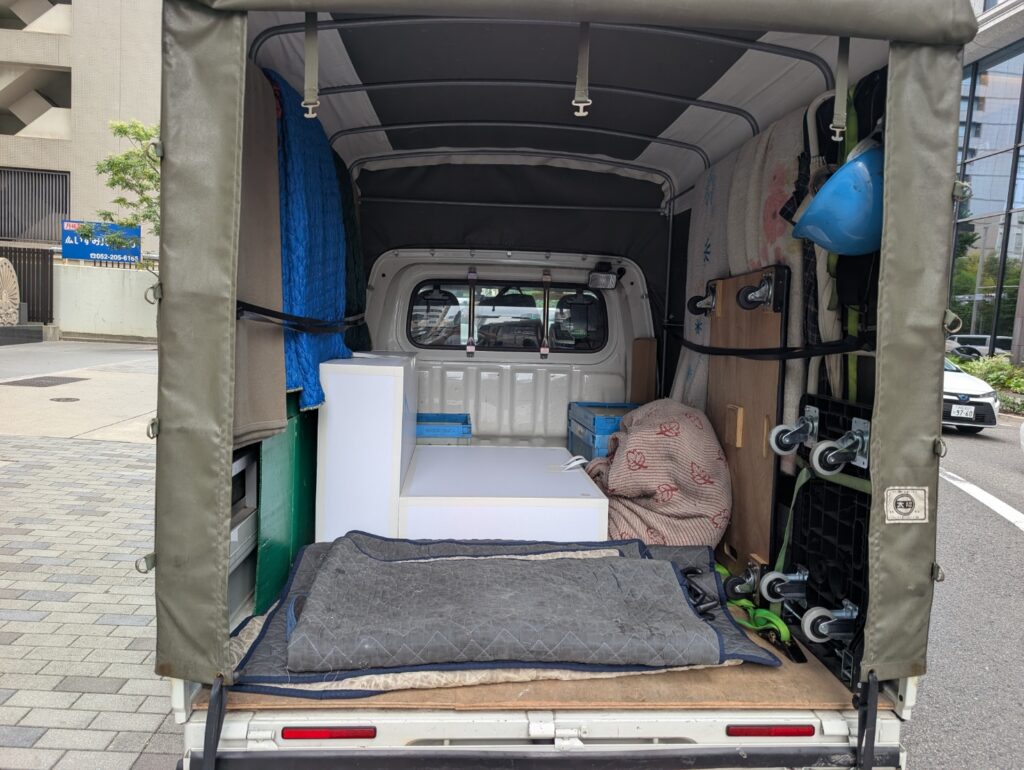 建築模型を丁寧に積載したトラック荷室の様子