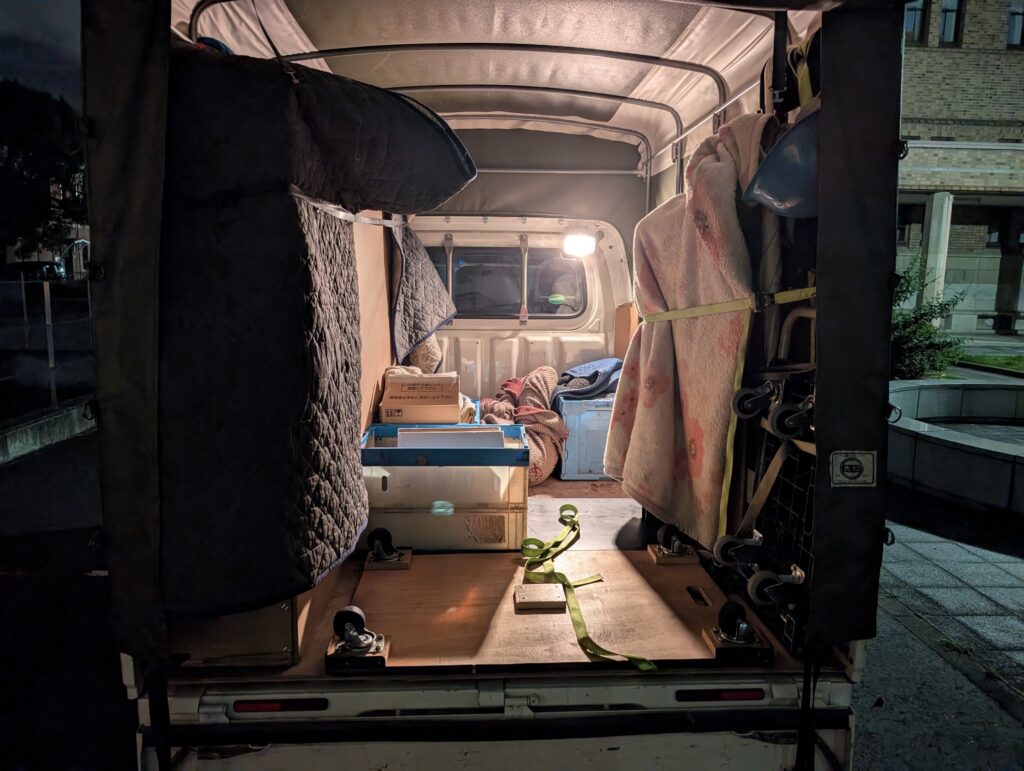 養生されたモニタースタンドと機材が安全に積載された赤帽松本運送の車内の様子（夜間）