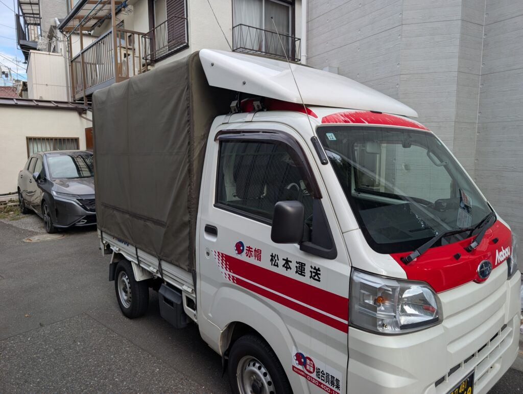 北区のアパート前に停車する赤帽トラック