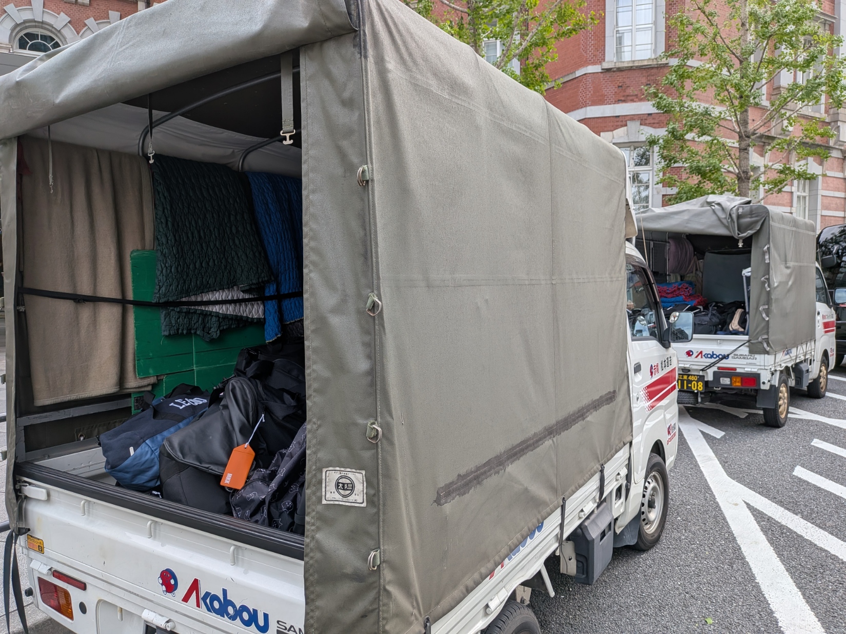 東京駅前で待機する赤帽トラック2台