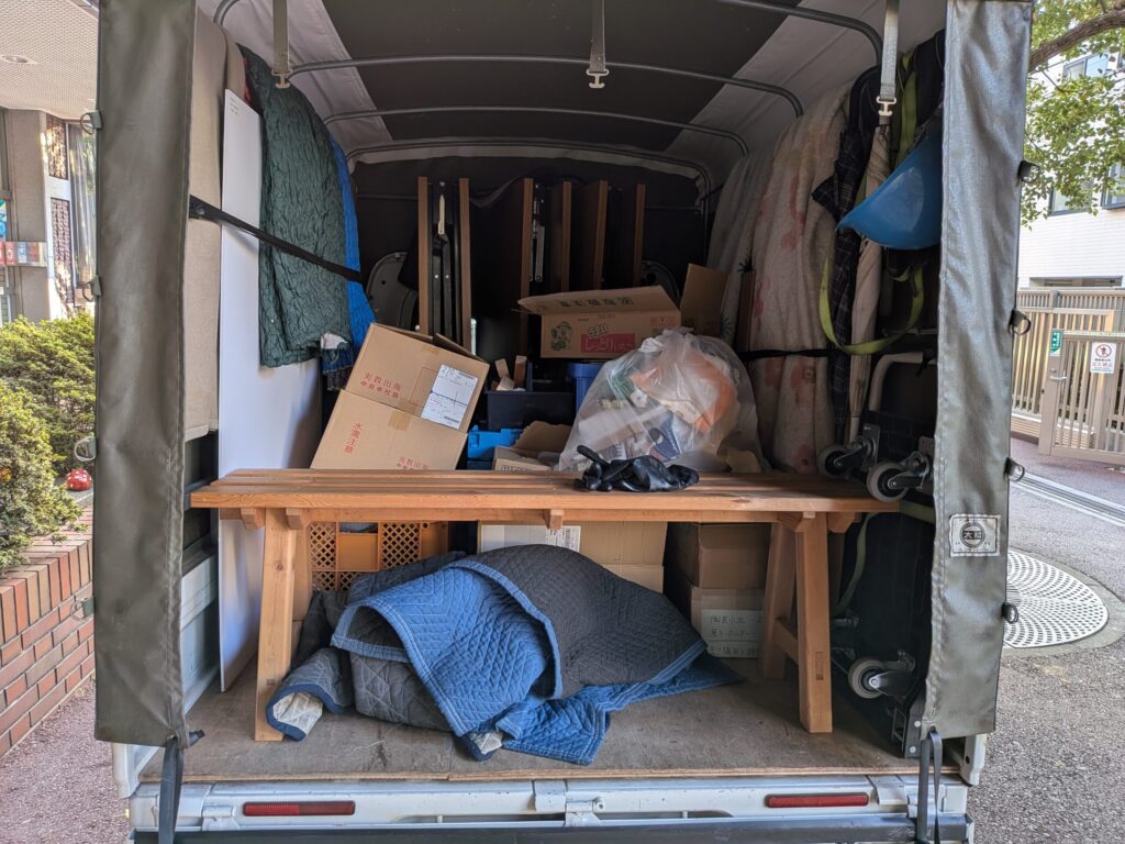 商店街イベントの撤収作業で荷物を積み込む赤帽松本運送トラック