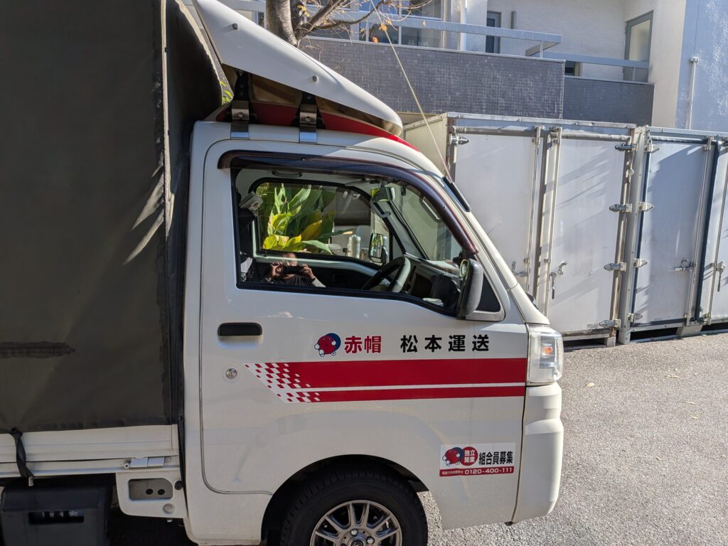 コンテナ倉庫前に停車した赤帽松本運送のトラック