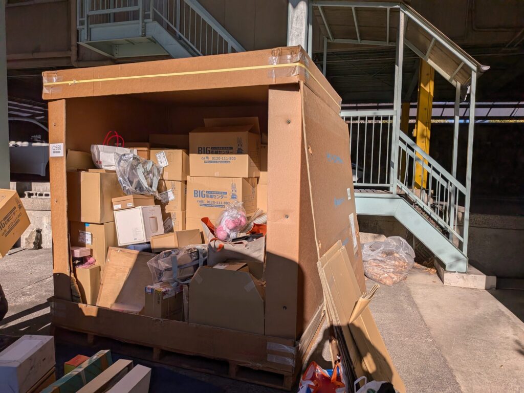 コンテナ倉庫内で荷物を選別しながら積み込んでいる様子