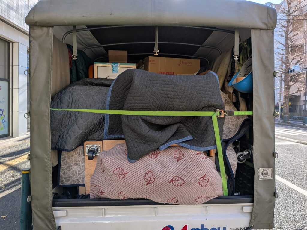 毛布で養生した荷物をトラックに積み込んだ様子