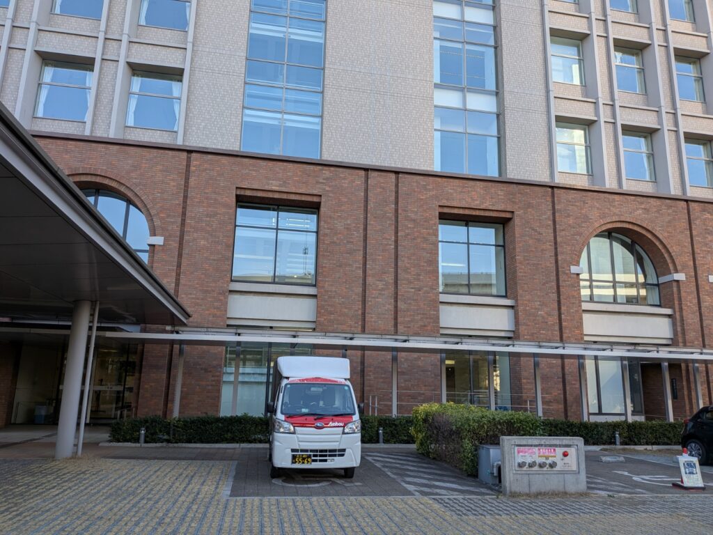 大学施設前での赤帽松本運送トラックの配送完了風景