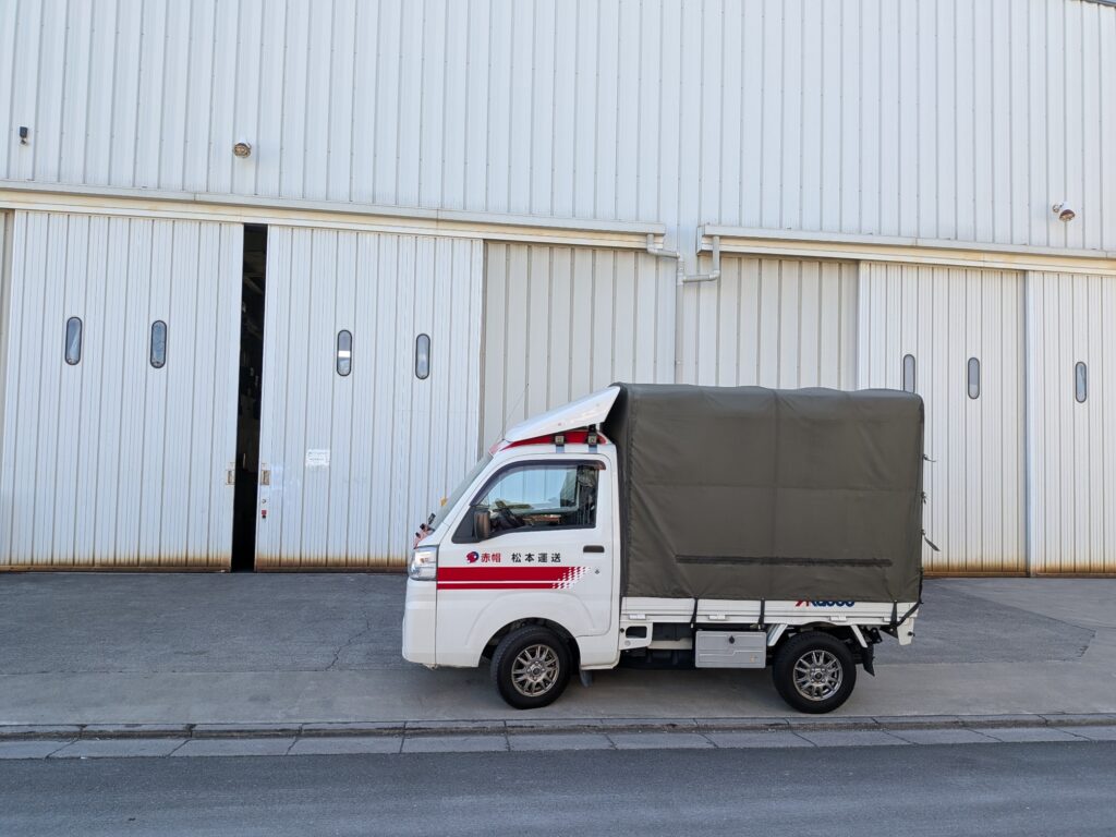 川口市の倉庫で緊急配送の荷物を引き取る赤帽松本運送のトラック