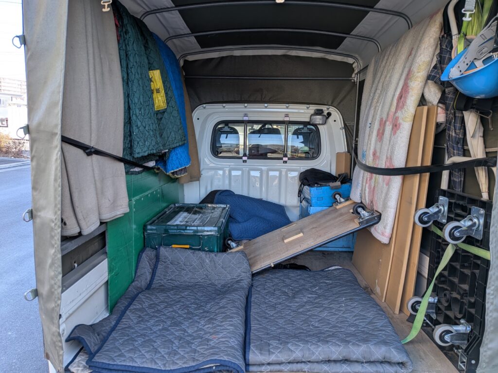 緊急配送の荷物を毛布・パッドで保護して固定した積載例