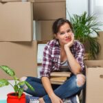 引越しの荷造りを終えて一息つく女性
