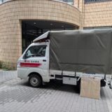 文京区の大学構内に駐車中の赤帽松本運送トラックと新品段ボール箱