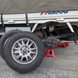 後輪交換中の赤帽トラックとスタッドレスタイヤの様子