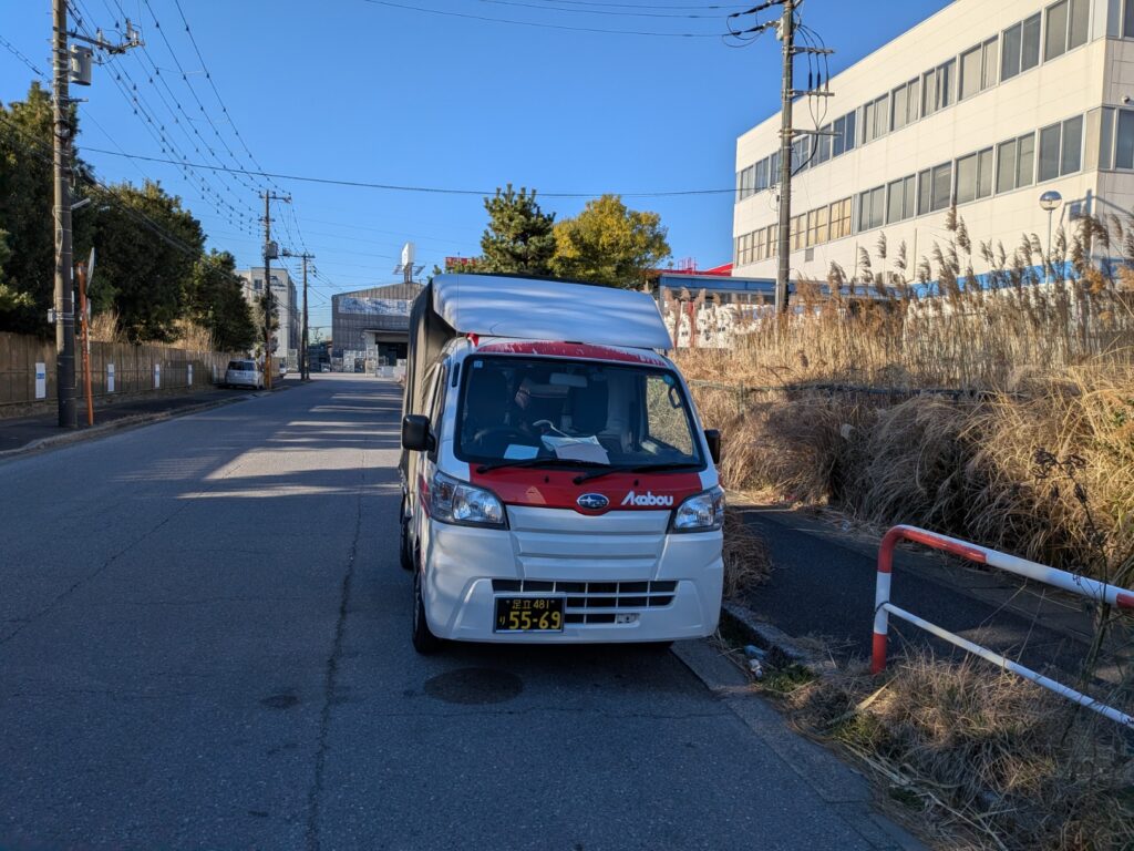 市川市の現場近くに停車した赤帽松本運送の軽トラック。朝一納品に合わせて到着した様子