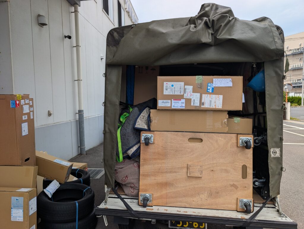 三郷市の板金工場で自動車部品を納品するため荷台の箱を確認している様子