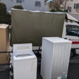 冷蔵庫と洗濯機を歩道に仮置きして積込み準備