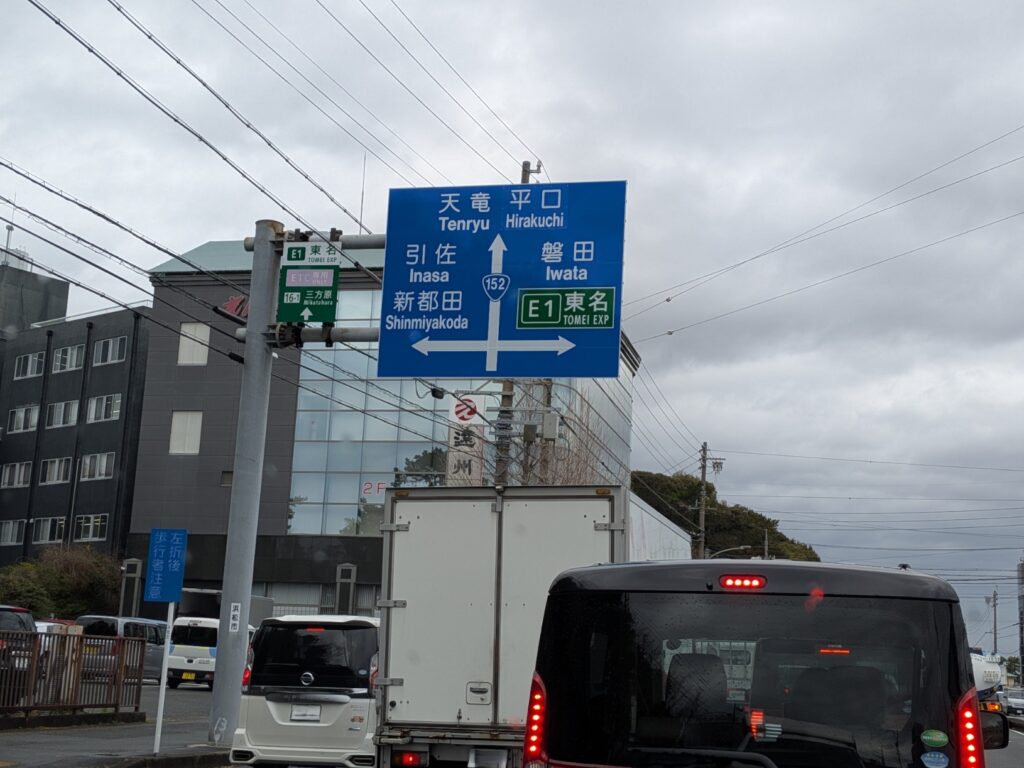 浜松市内の道路標識付近を走行中の赤帽トラック