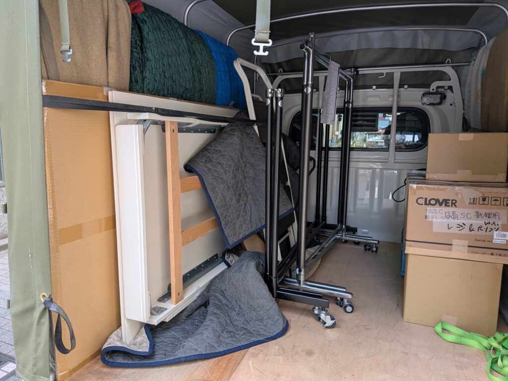 テーブルやハンガーラックを積み込んでいる様子