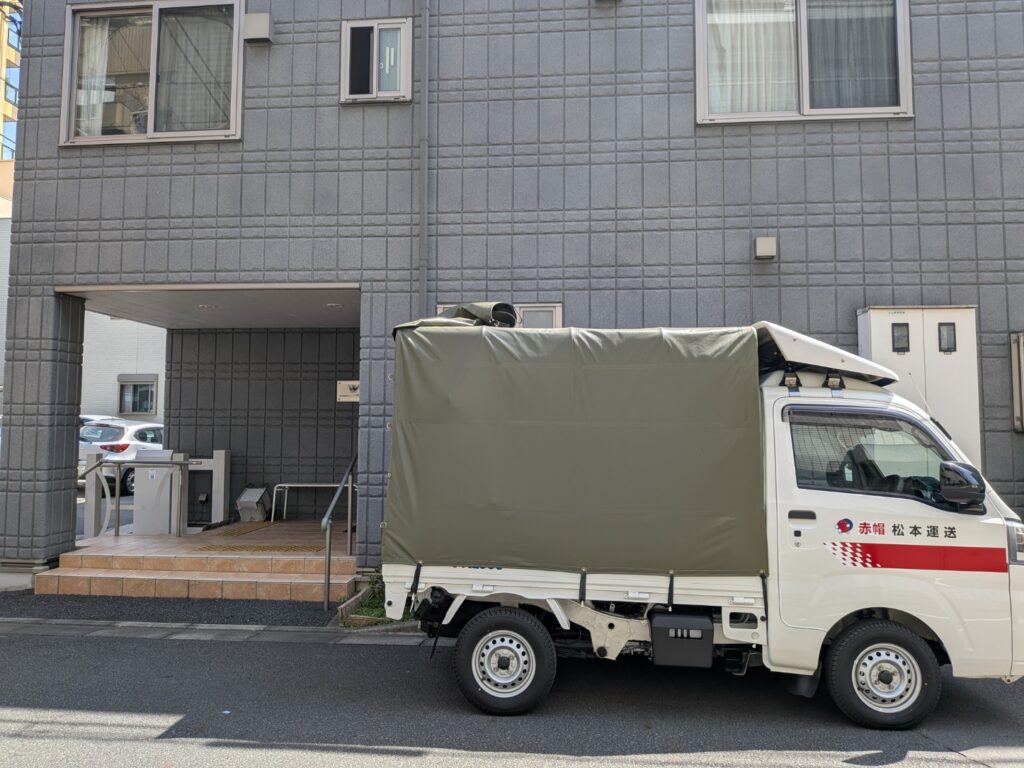 墨田区内グループホーム前で搬入作業中の赤帽松本運送トラック
