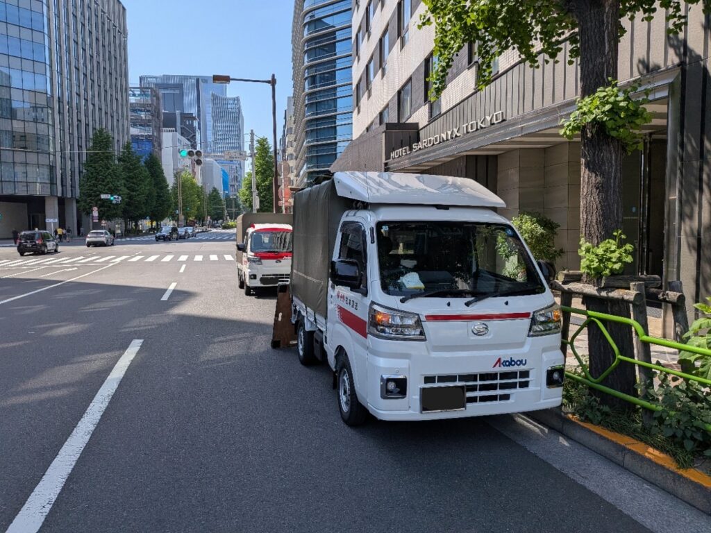 八丁堀ホテル前に到着した赤帽トラック2台 団体カバン配送
