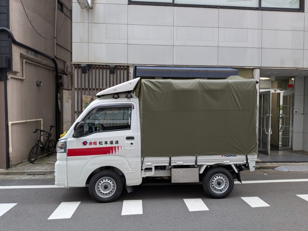中央区の会社前に停車した赤帽松本運送の軽トラック