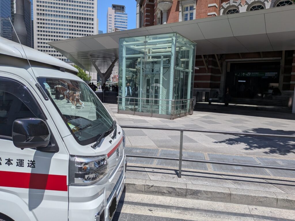東京駅前で修学旅行カバン配送に対応する赤帽松本運送トラック