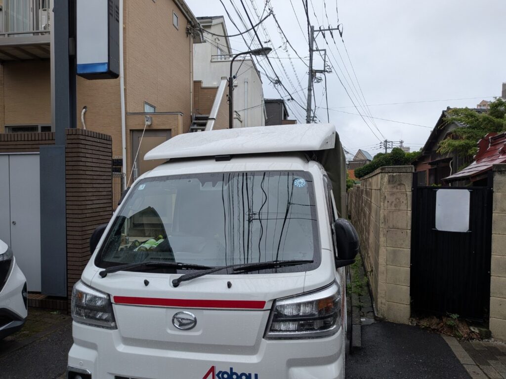 新宿区のアパート前に到着した赤帽松本運送のトラック
