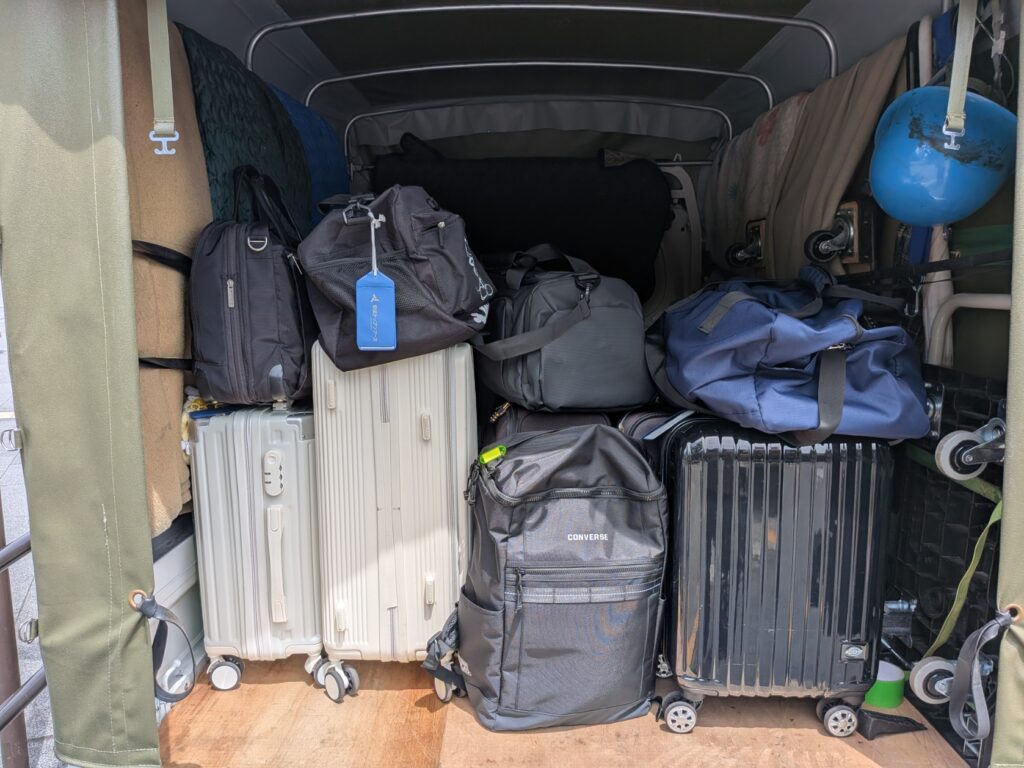 修学旅行のスーツケースを積み込んだ赤帽トラック荷台