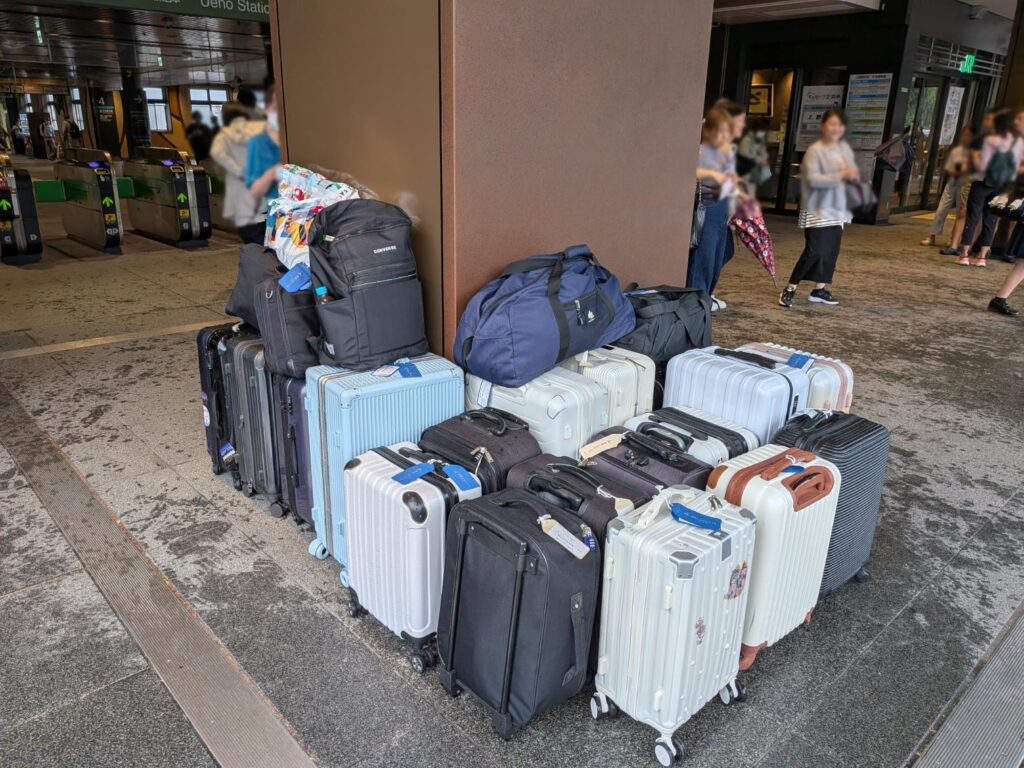 上野駅公園口改札付近で修学旅行スーツケースを引き渡す様子