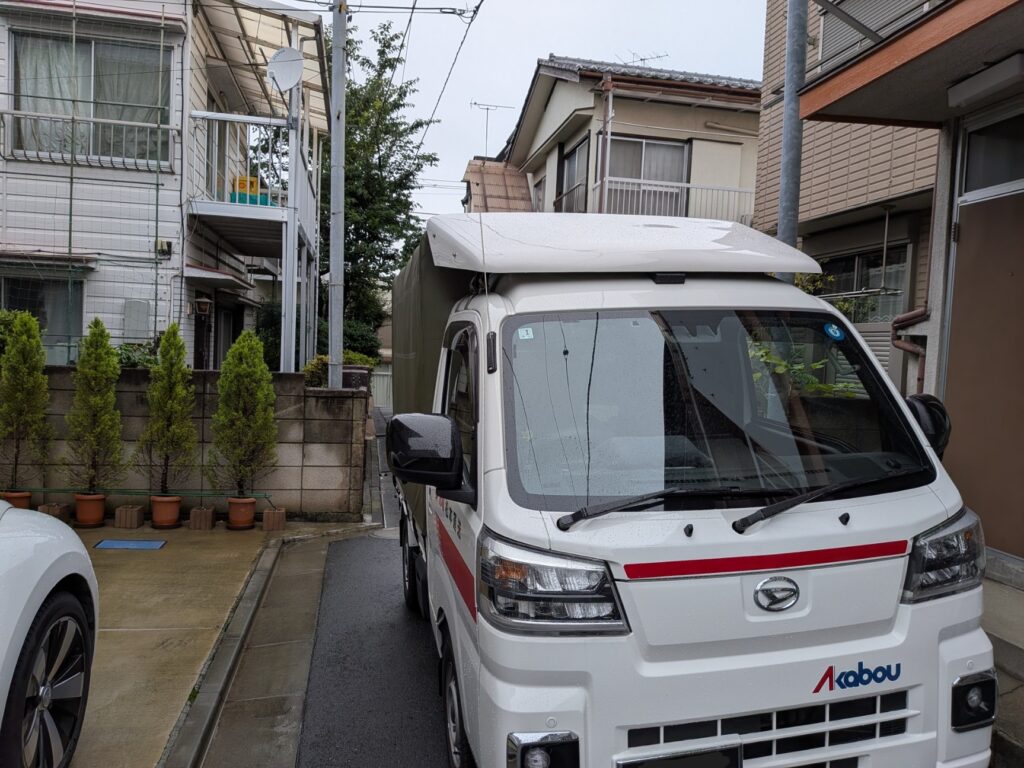 板橋区マンション前で自転車配送に対応する赤帽松本運送トラック