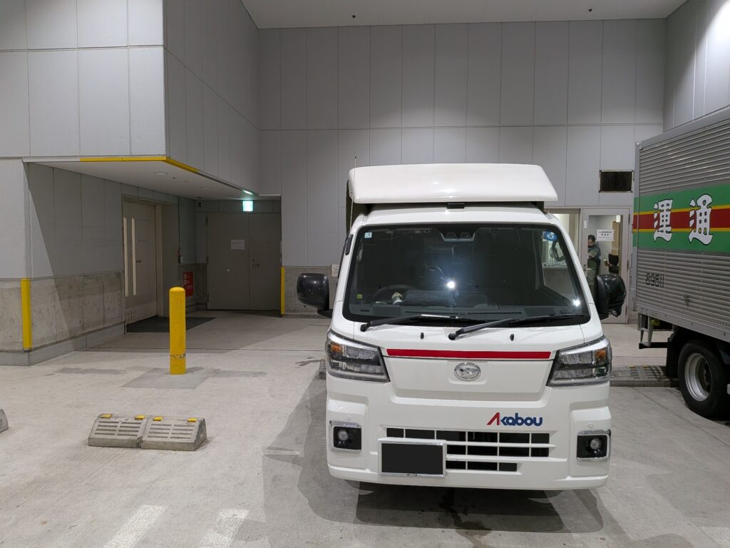 横浜のデパート搬入口で搬入作業を行う赤帽松本運送トラック