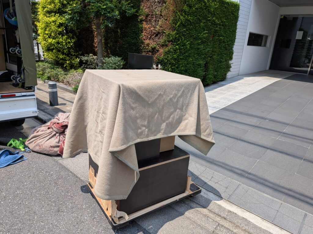 毛布で養生した机を慎重に運ぶ様子