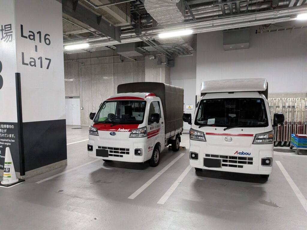 江東区有明のホテル地下駐車場で修学旅行カバン配送に対応する赤帽トラック2台