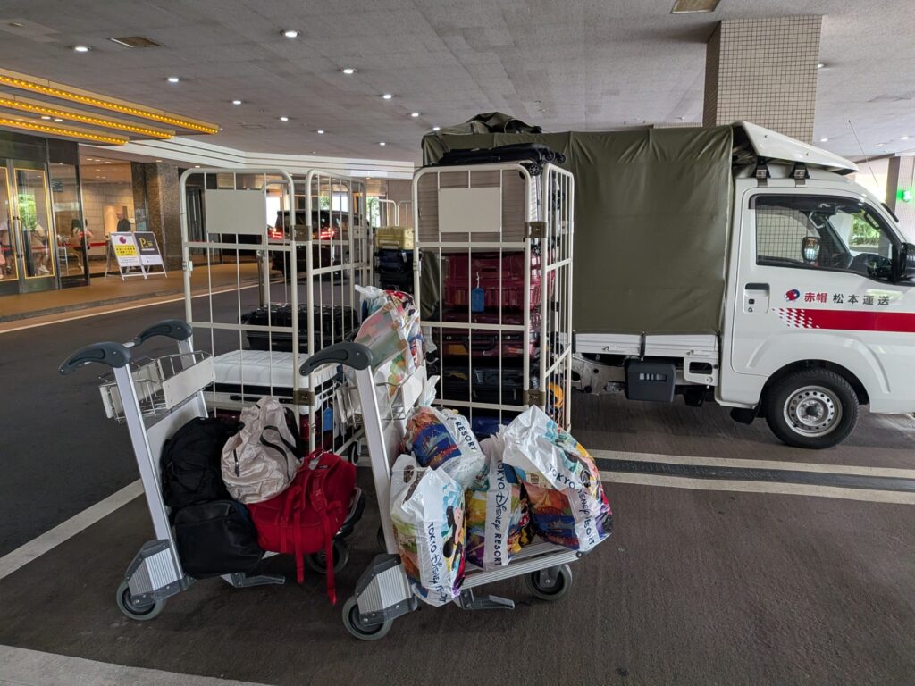 修学旅行のお土産とスーツケースをかご台車へまとめた様子