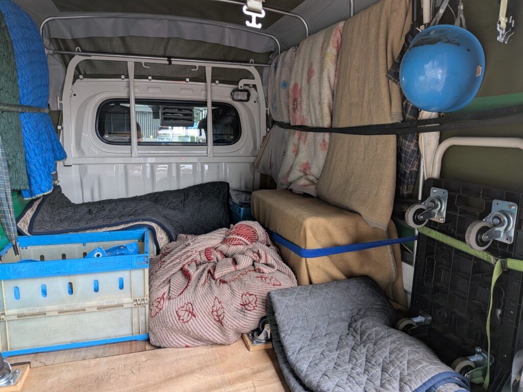 ジオラマ模型の周囲を毛布やオリコンで保護した赤帽松本運送トラックの荷台