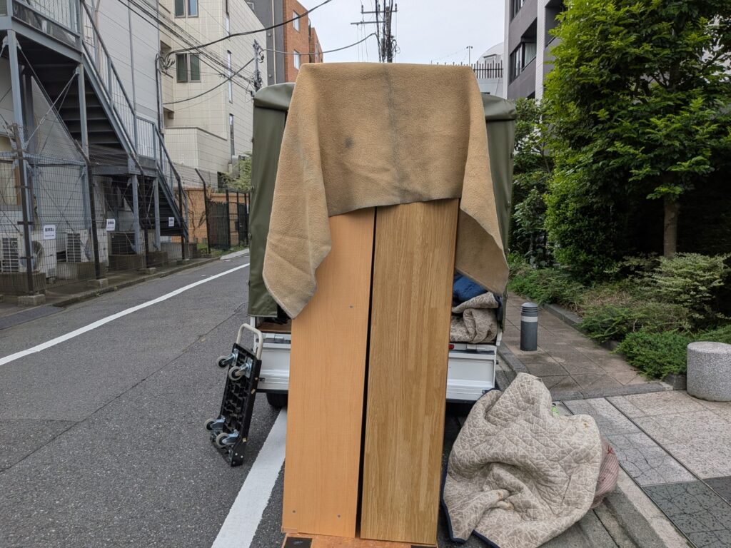 本棚2本を平台車に乗せて運んでいる様子