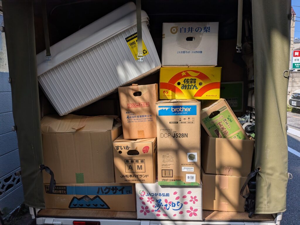 段ボールを満載に積み込んだ赤帽トラックの荷台