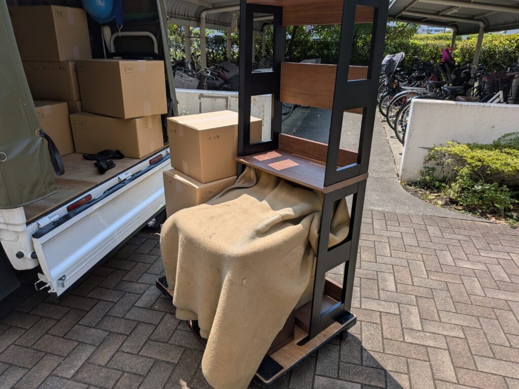 仏壇や棚・段ボールを台車で搬出している様子