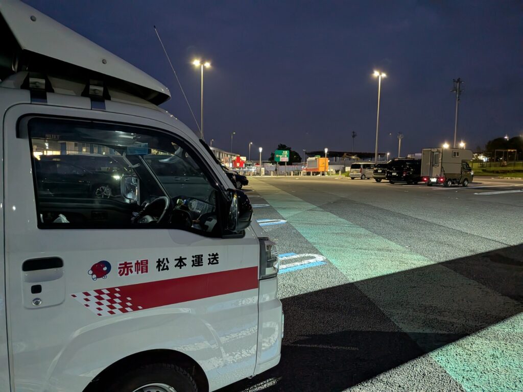 深夜のサービスエリアで休憩する建築模型長距離配送中の赤帽松本運送