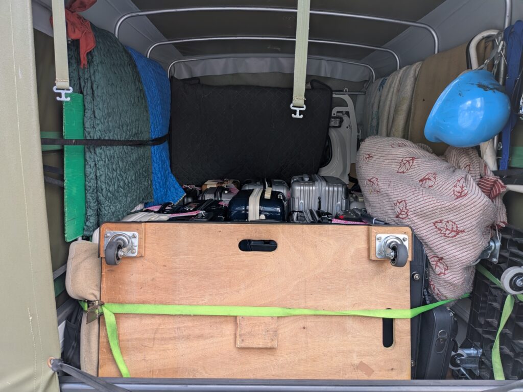 修学旅行のスーツケースを荷崩れしないよう固定した赤帽トラックの荷台