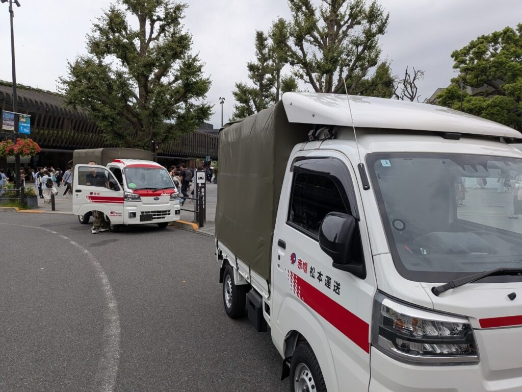 上野駅公園口に集合した修学旅行のカバン配送を担当する赤帽トラック2台