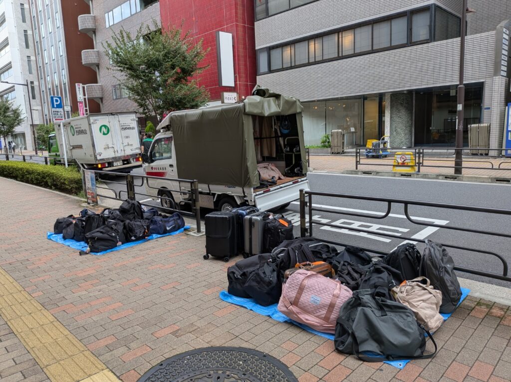 上野駅で修学旅行の生徒さんへ渡すカバンをブルーシートの上に並べた様子