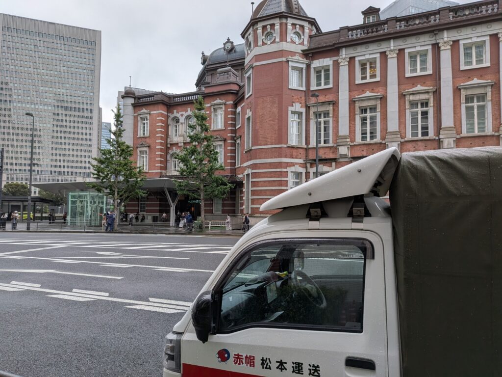 東京駅丸の内南口で修学旅行のカバンを集荷する赤帽車