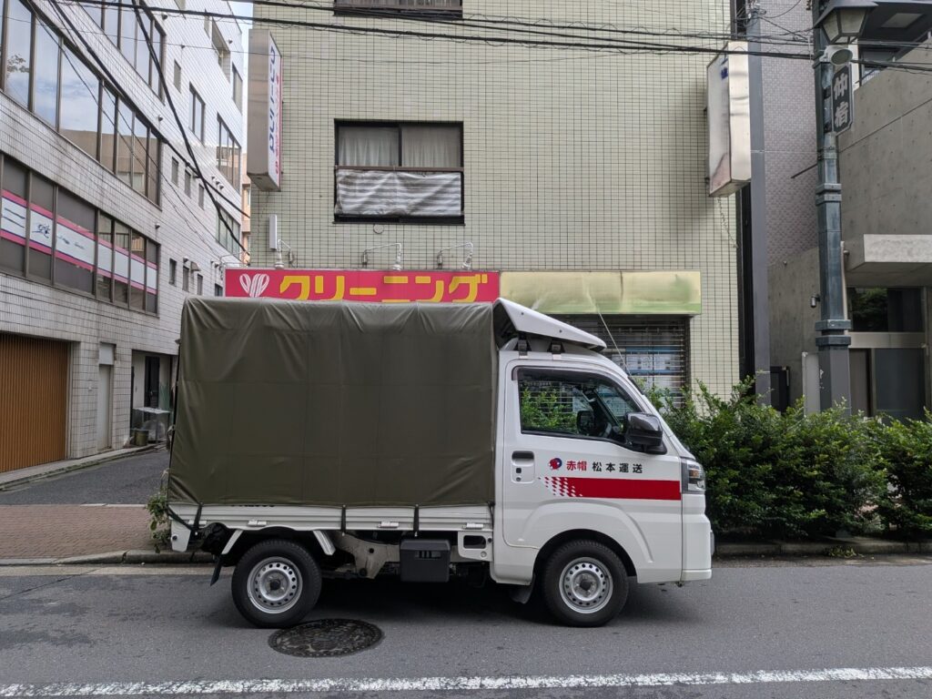 東京都板橋区仲宿のクリーニング店前に停車した赤帽松本運送の軽トラック